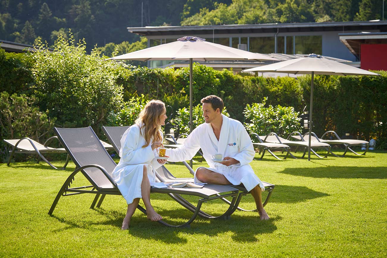 Sonniger Sauna Außenbereich mit einem Pärchen auf Relax-Liegen